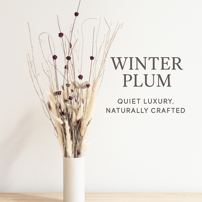 Winter Plum Dried Floral Arrangement in a white vase on a wooden surface with soft natural light. Elegant dried flowers in plum and cream tones beside text that reads “Winter Plum – Quiet Luxury, Naturally Crafted.
